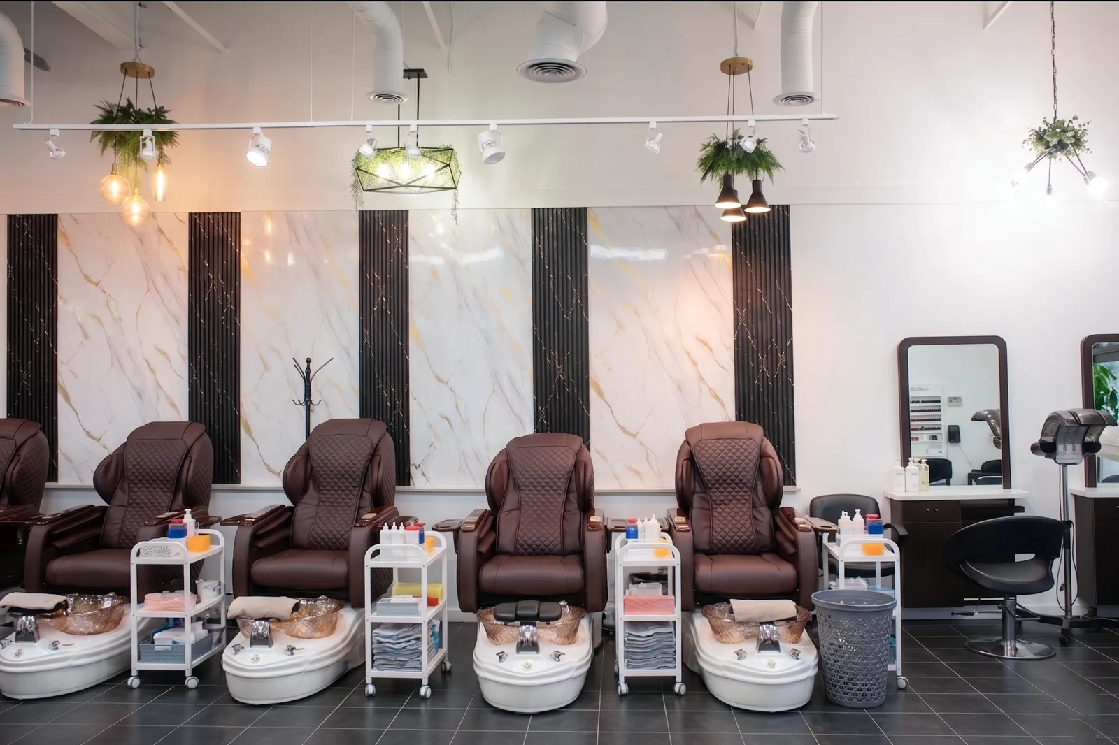 Massage and pedicure chairs in a calm spa treatment area at Herbal Hair and Spa